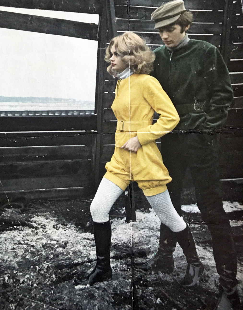 Retro fashion moment with a woman in a vibrant yellow outfit and ACQUO of Sweden glossy knee-high boots, styled with white textured tights – iconic Swedish outerwear style from the vintage era, highlighting bold design and timeless elegance