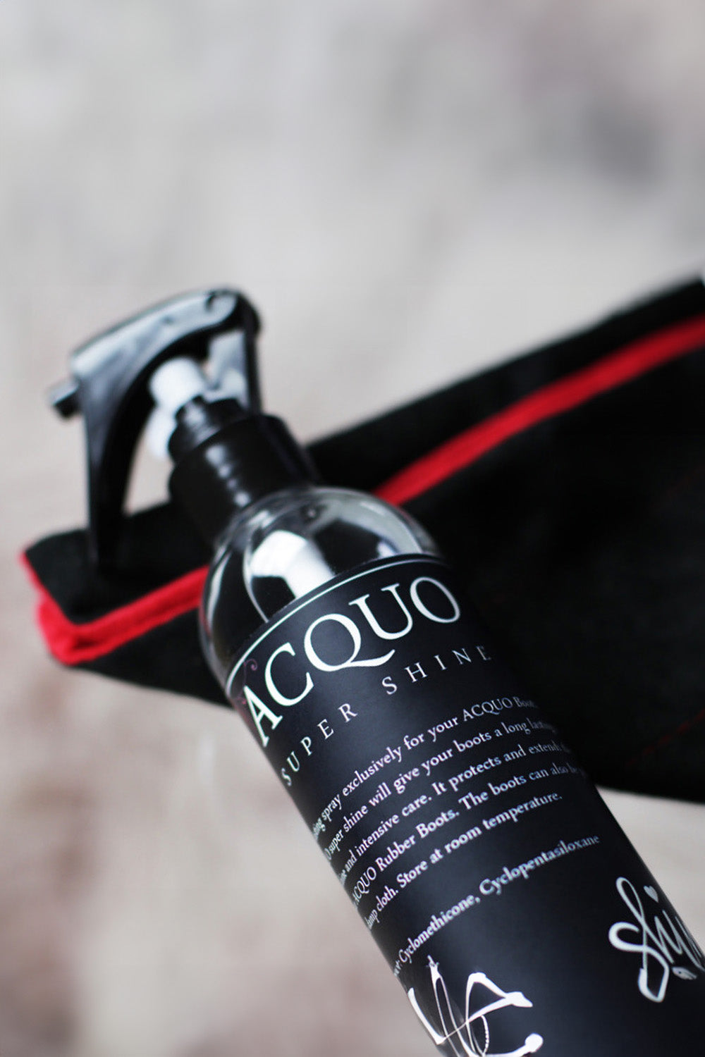 Close-up of ACQUO of Sweden Super Shine spray bottle, specially formulated to polish and protect ACQUO rubber boots for a lasting, radiant finish