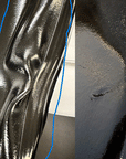 Close-up comparison of an ACQUO of Sweden over-the-knee black rubber boot showing visible creasing on the shaft and a surface scratch on the side, highlighted for detailed quality evaluation