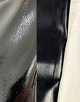 Close-up of ACQUO of Sweden black rubber boot surface with visible dents, scratches, and irregular texture imperfections