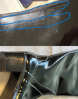 Detailed inspection of black glossy ACQUO of Sweden over the knee boots, showcasing light surface marks and creases on the shaft and heel area, emphasizing the handcrafted rubber boot quality and finish