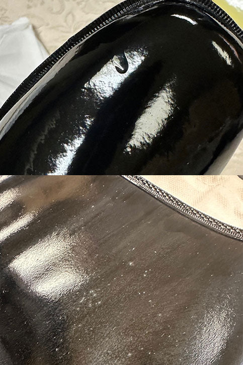 Close-up of ACQUO of Sweden's black rubber boots highlighting a minor surface cut and scattered white speckles—showcasing the natural imperfections found in handcrafted fashion footwear made from premium materials