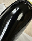 Detailed view of ACQUO of Sweden's black over-the-knee rubber boot, featuring a visible surface mark near the toe area—demonstrating the unique characteristics of handcrafted, high-shine designer footwear