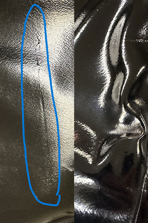 Close-up of black over the knee rubber boots by ACQUO of Sweden, highlighting minor surface imperfections and vertical crease lines on the shaft, indicative of the handmade character and material texture of premium high-shine fashion boots.