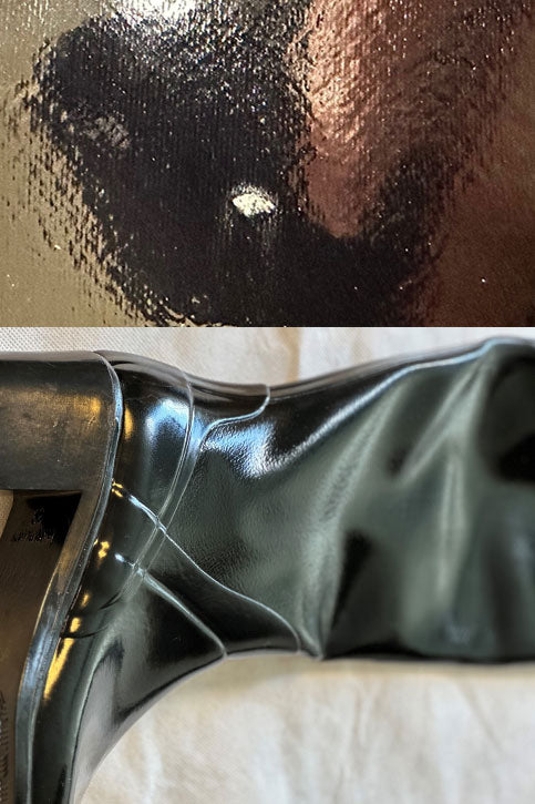 Detail view of ACQUO of Sweden's black over the knee rubber boots, showing a distinct mark on the toe area and natural creases around the ankle, demonstrating the handcrafted nature and unique surface character of each boot