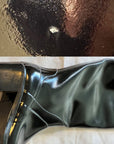 Detail view of ACQUO of Sweden's black over the knee rubber boots, showing a distinct mark on the toe area and natural creases around the ankle, demonstrating the handcrafted nature and unique surface character of each boot