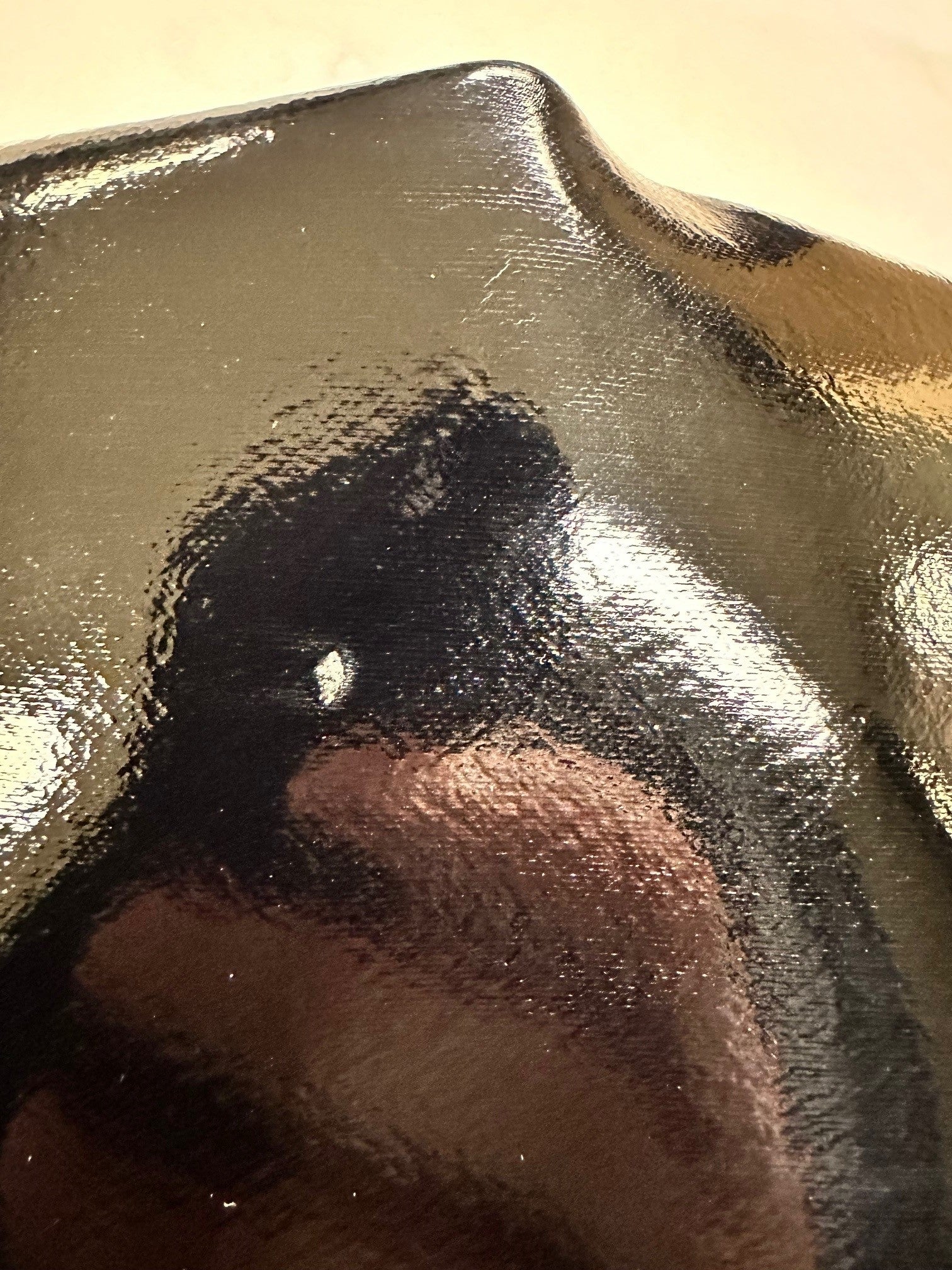 Close-up of ACQUO of Sweden's black rubber boot showing a minor surface imperfection, highlighting the high-shine texture and craftsmanship of the material used in their signature over the knee fashion boots