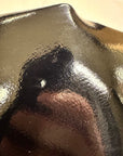 Close-up of ACQUO of Sweden's black rubber boot showing a minor surface imperfection, highlighting the high-shine texture and craftsmanship of the material used in their signature over the knee fashion boots