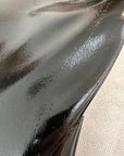 Close-up of ACQUO of Sweden's black rubber boot showing a minor surface imperfection, highlighting the high-shine texture and craftsmanship of the material used in their signature over the knee fashion boots