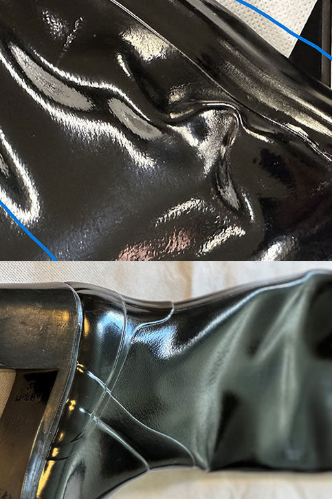 Close-up of ACQUO of Sweden black rubber boot surface with deep wrinkles, dents, and visible creases in the material