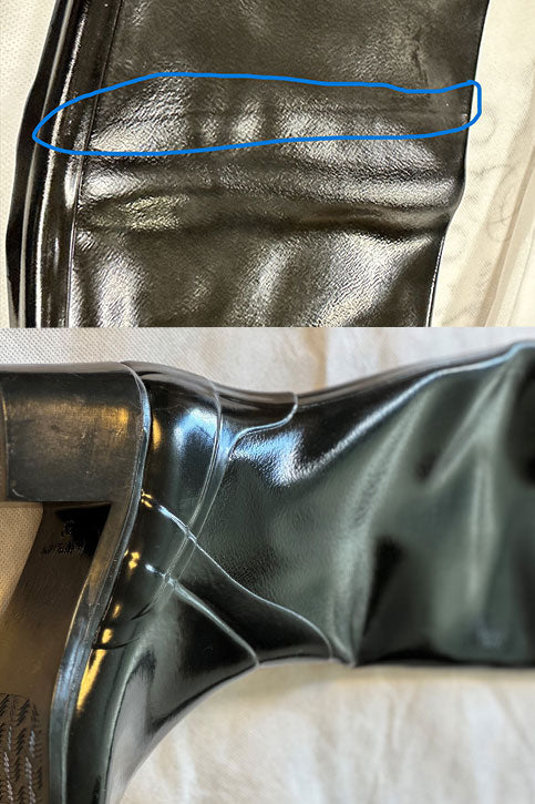 Close-up of ACQUO of Sweden black rubber boot surface with visible wrinkles, creases, and irregular texture imperfections