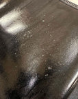 Close-up of ACQUO of Sweden black rubber boot surface with visible spots, bubbles, and uneven texture imperfections